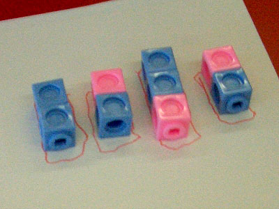 Four groups of coloured cubes: a blue-blue pair, a blue-pink pair, a pink-blue-blue group, and another blue-pink pair.