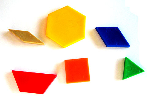 Six shapes: a small brown rhombus, a yellow hexagon, a larger blue rhombus, a red trapezium, an orange square and a green equilateral triangle.