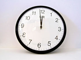 Full face of an analogue clock, showing time as two minutes to twelve.